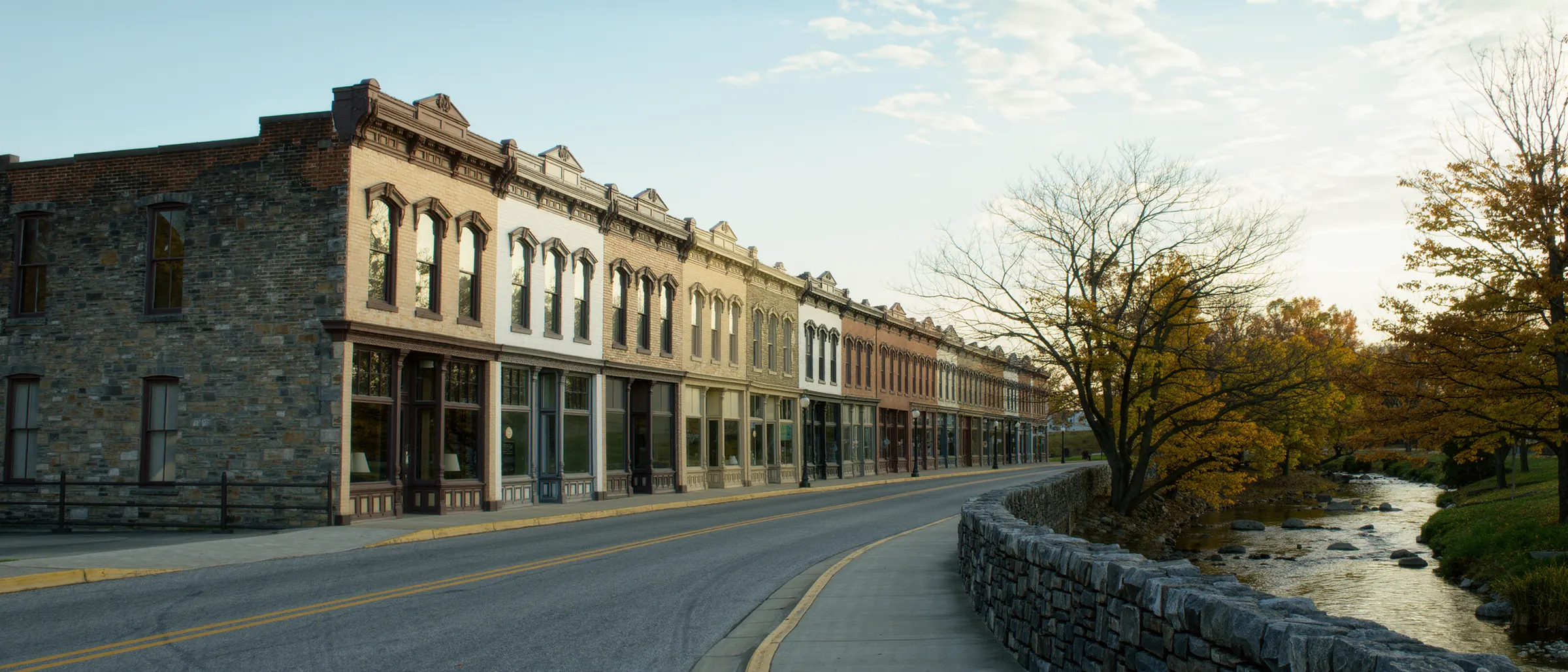 Historic stone storefront buildings along a riverside street