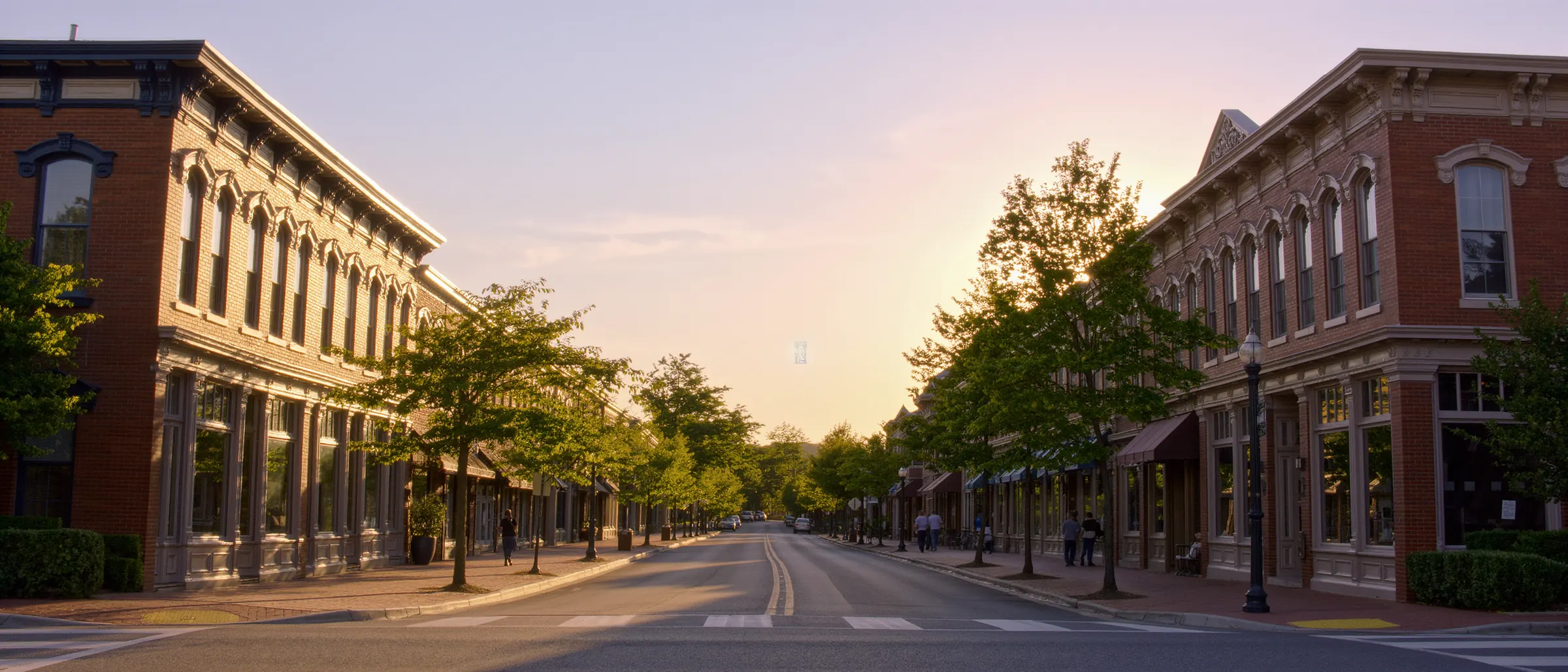 A brick main street with Victorian storefronts at golden hour