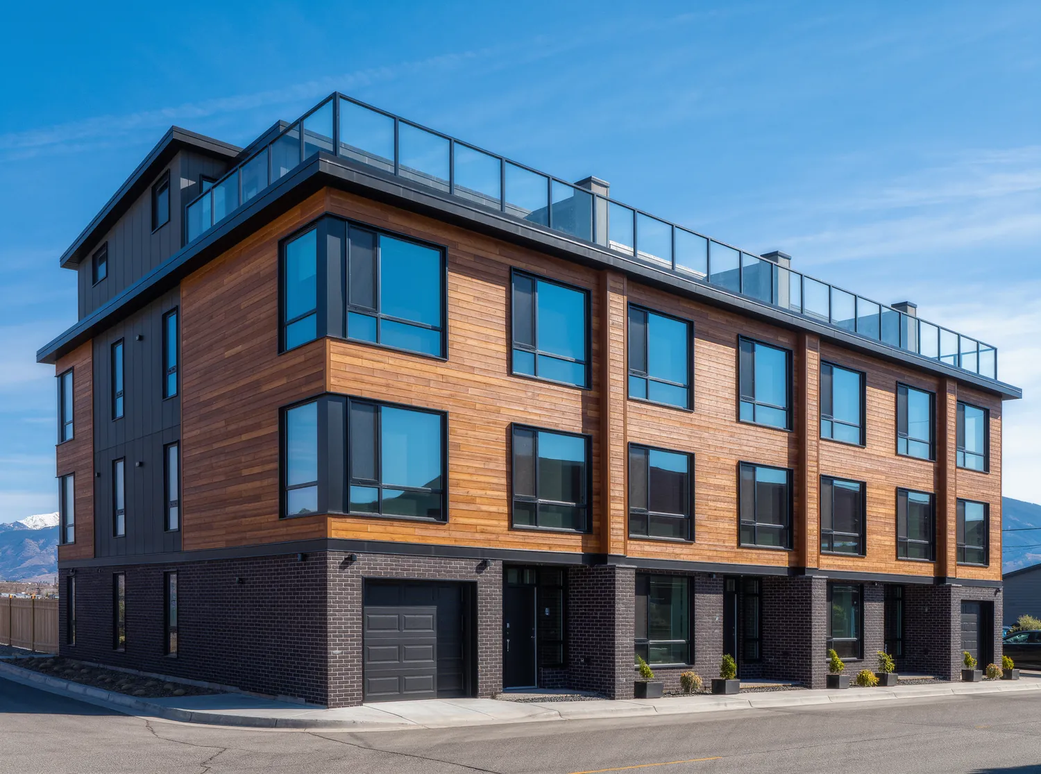 A modern three story townhome with dark brick, cedar siding, black framed windows and a rooftop deck
